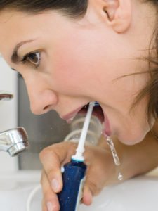Bei der Anwendung einer Munddusche ist wichtig, dass das Wasser zum Schluss wieder aus dem Mund fließen kann.